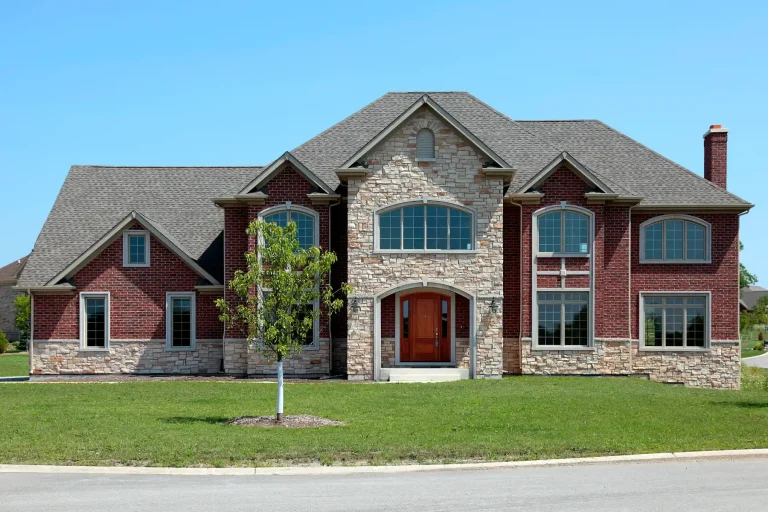 Two-story brick and stone home with a front lawn